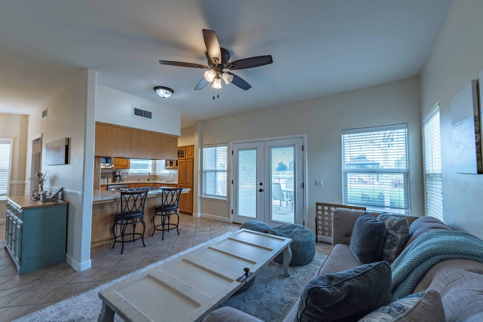 Relax in your open-concept living space with comfortable seating, ceiling fan, and easy access to your private balcony.
