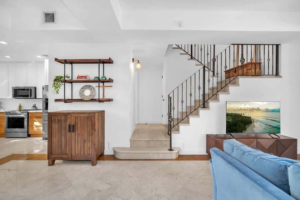 Open living space with easy access to the upper floor via a chic staircase, near the kitchen and lounge.