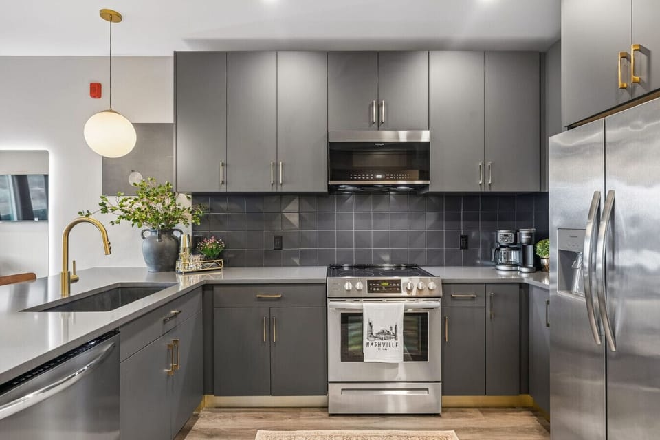 Pristine kitchen with dark finishes, fully stocked and guest-ready.