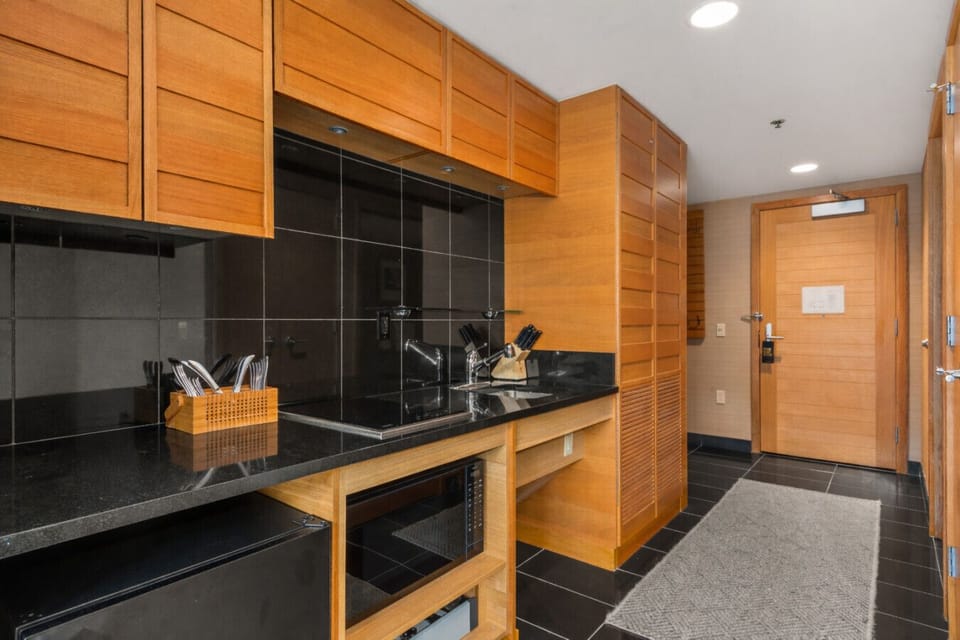 The kitchenette may be small, but it packs a punch — equipped with a stove, fridge, microwave, and all the essentials for cooking small meals.