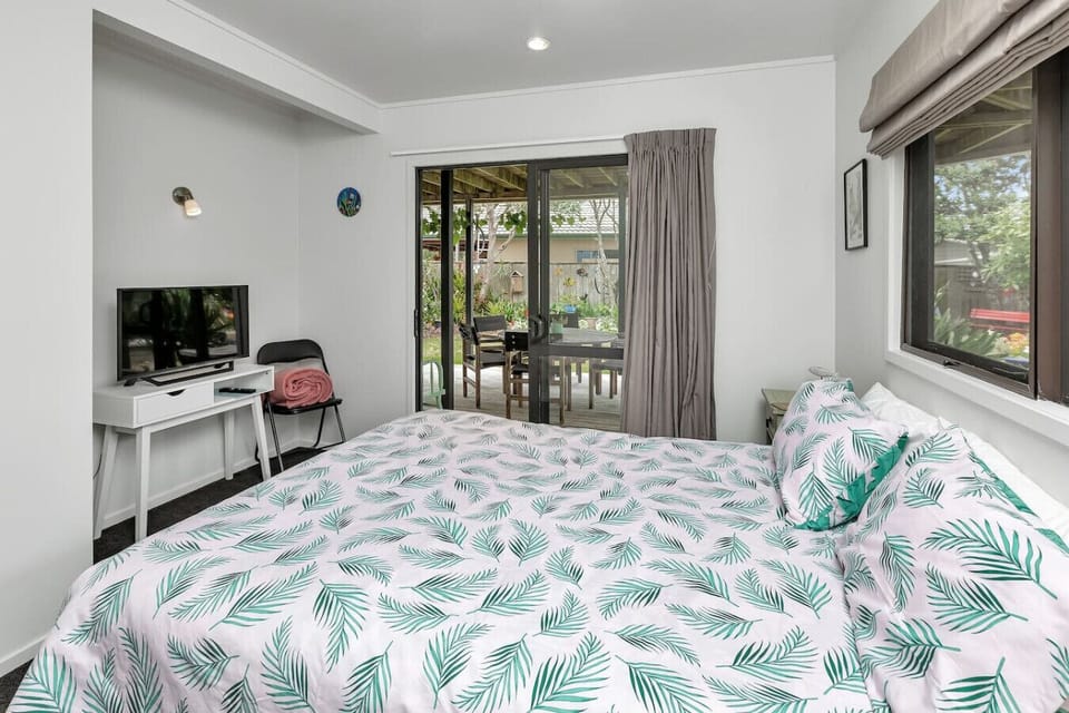 Bedroom 2 with queen bed, smart TV, and direct access to the garden