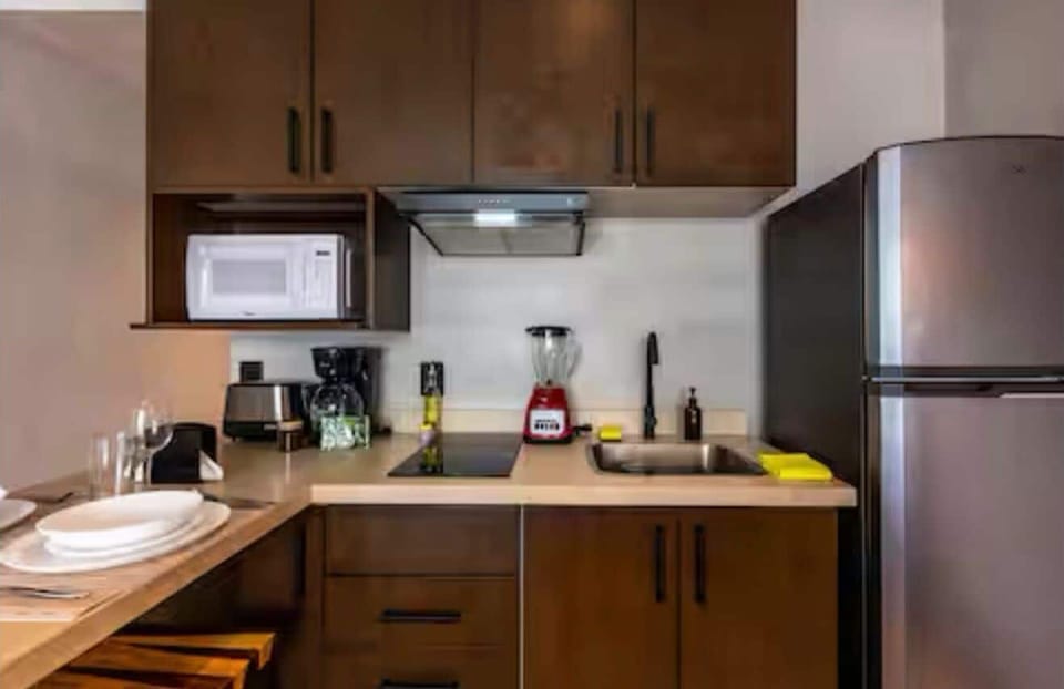 Deluxe Condo, Balcony, Pool View | Private kitchen | Full-size fridge, microwave, dishwasher, cookware/dishes/utensils