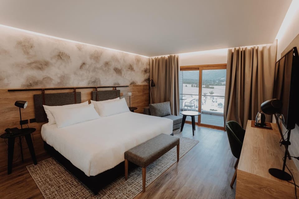 Step into your bright room with balcony views and calm comfort.