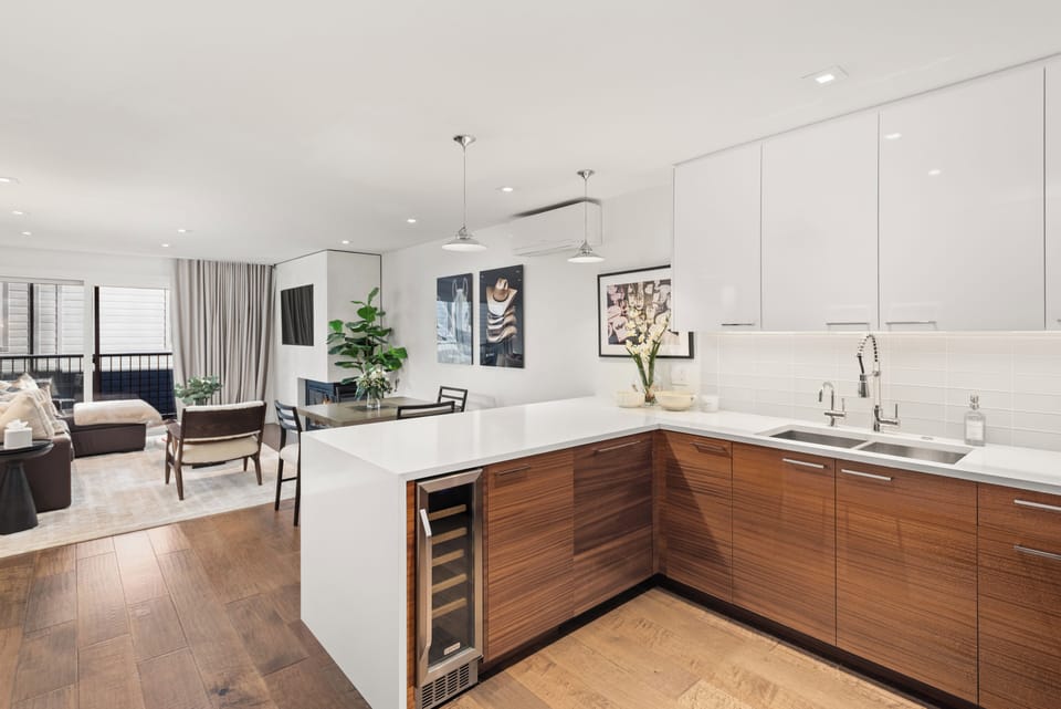 Open-concept kitchen, living, and dining room with gas fireplace and high-end finishes. The living room has a plush queen-sized sleeper sofa for the fifth and sixth guests, if needed.