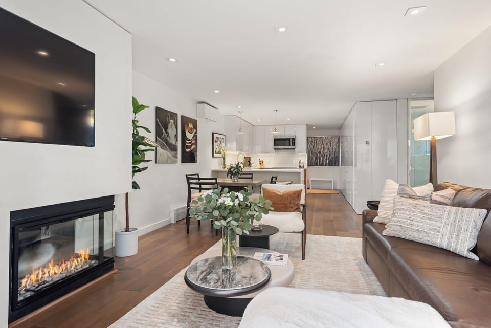 Open-concept kitchen, living, and dining room with gas fireplace and high-end finishes. The living room has a plush queen-sized sleeper sofa for the fifth and sixth guests, if needed.