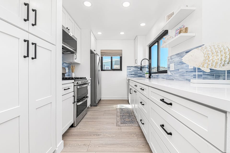 Cook with ease in the modern kitchen, equipped with full appliances and a large window view of the deck
                