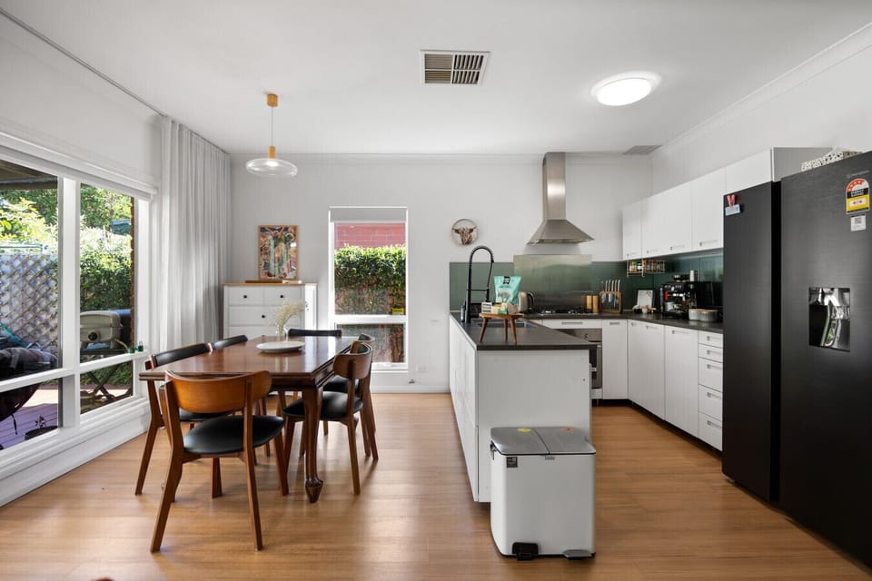 The dining table sits beside the kitchen and living space, making it easy to gather for meals and conversation.