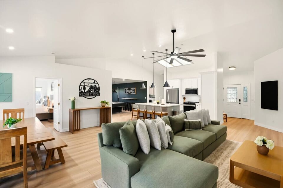 Open-concept living and dining room with comfortable couch, fully equipped kitchen and access to the game room