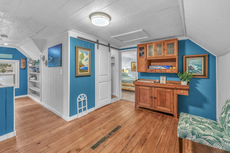 Step into your charming coastal retreat where ocean-blue walls meet warm wood floors, creating the perfect seaside sanctuary for relaxation.
