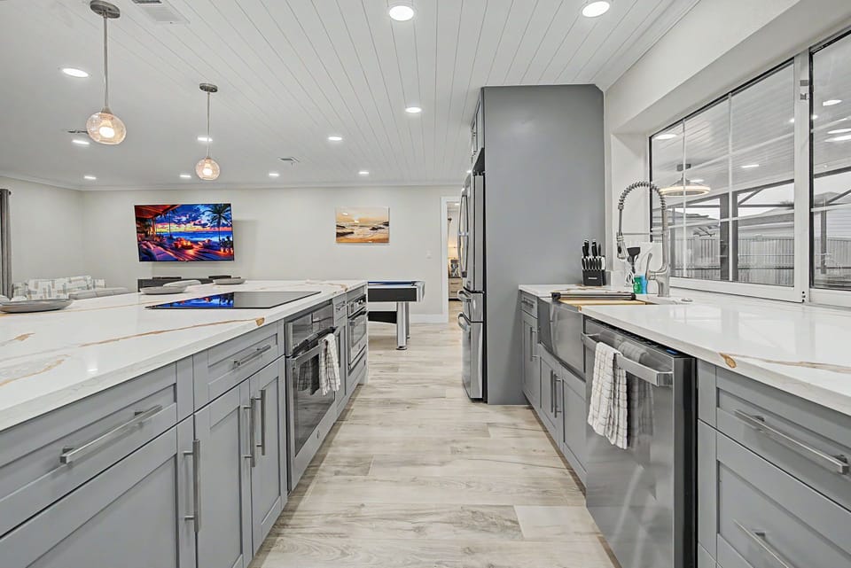 Step into your spacious gourmet kitchen with sleek gray cabinetry, gleaming quartz countertops, and modern stainless appliances—perfect for preparing delicious meals together during your stay.