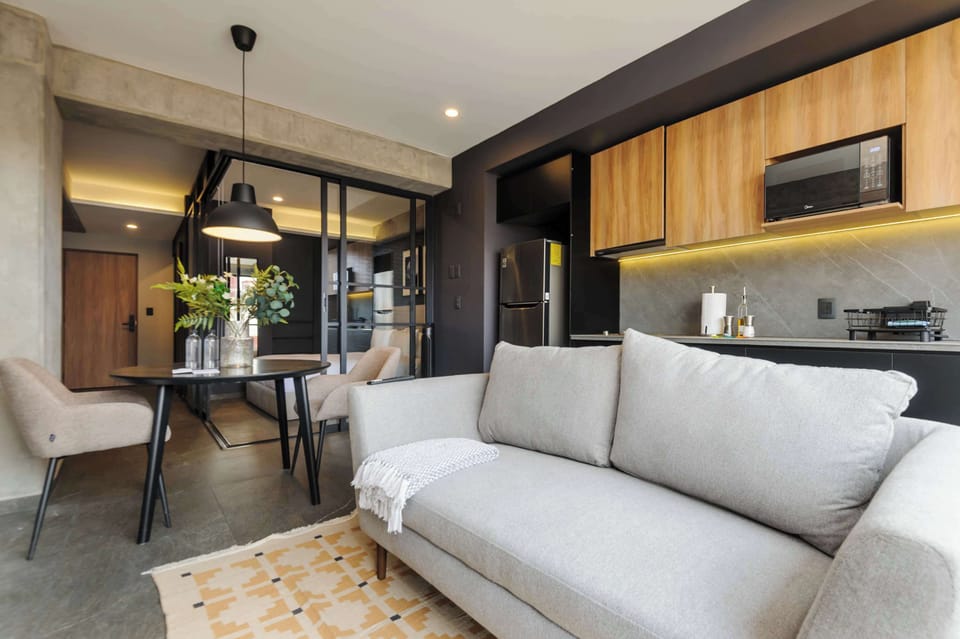 Elegant living area with modern decor and a fully integrated kitchen behind.