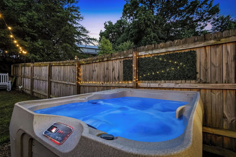 Soak away the day in your private hot tub, surrounded by twinkling lights and lush greenery for the ultimate evening escape.