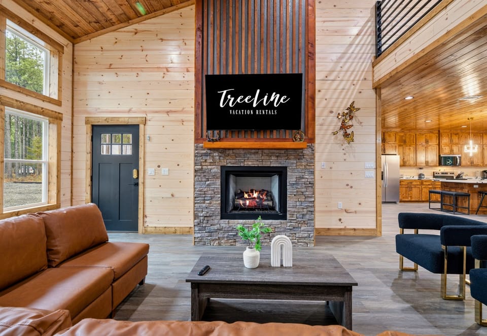 A bright and inviting sitting area near the fireplace offers another comfortable spot to chat, read, or simply enjoy the peaceful cabin atmosphere.