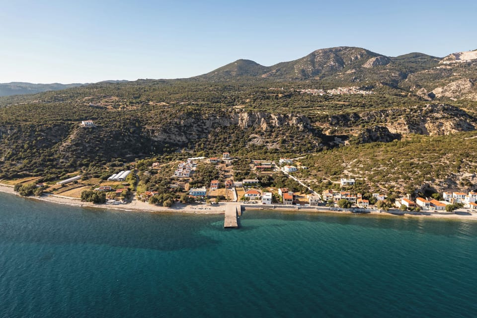 Aerial view of the peaceful Ormos Koumeikon coastline, where crystal-clear waters meet a quiet seaside setting beneath the slopes of Mount Kerkis, just moments from the villa and close to Koumeika village, local tavernas, and nearby beaches.