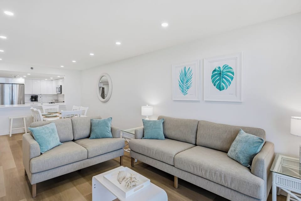 Relax in your bright, modern living space with coastal-inspired decor and comfortable seating that flows seamlessly into the dining area.