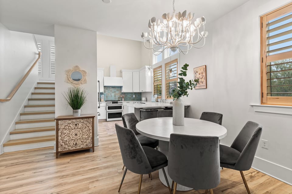 Gather around this elegant dining table beneath the stunning chandelier, with the modern kitchen just steps away for easy entertaining.