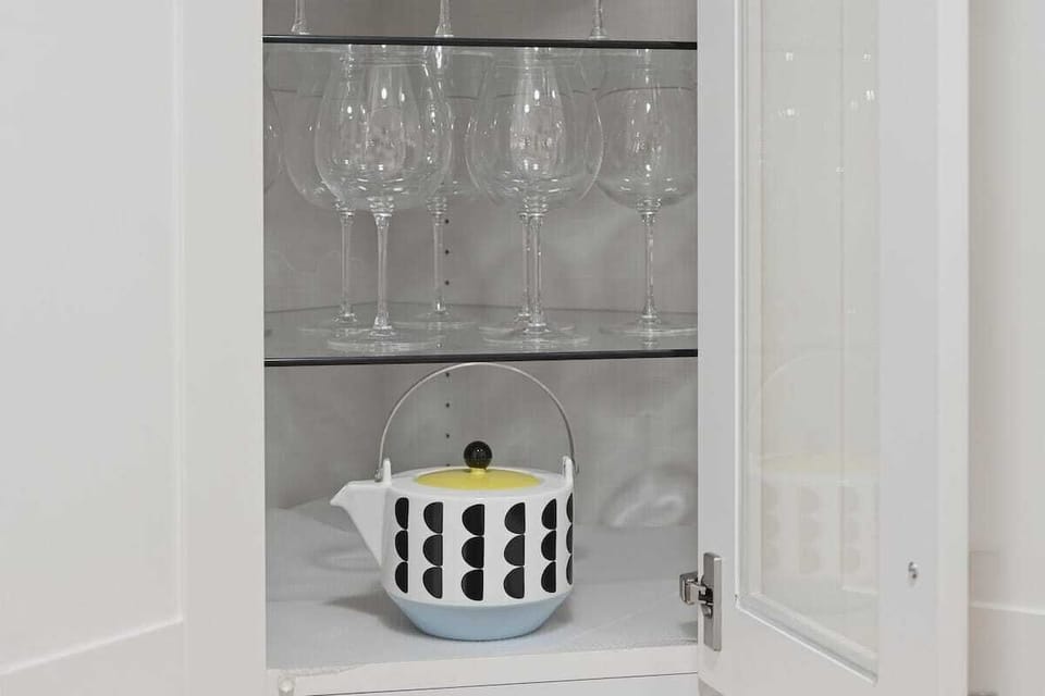 Fully equipped kitchen cabinet with wine glasses and an ice bucket, providing everything needed for entertaining and relaxing evenings. 🍷✨