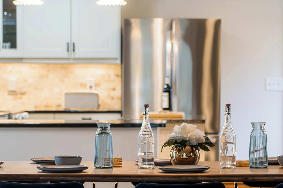 Modern dining area with stylish table setting, conveniently located beside the fully equipped kitchen for easy meal preparation and entertaining. 🍽️✨