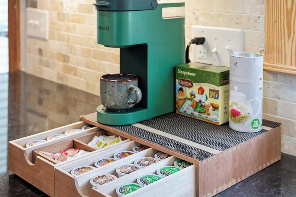 Convenient coffee and tea station featuring a pod coffee machine, organized drawer with assorted capsules, sweeteners, and essentials — perfect for an easy morning start. ☕✨