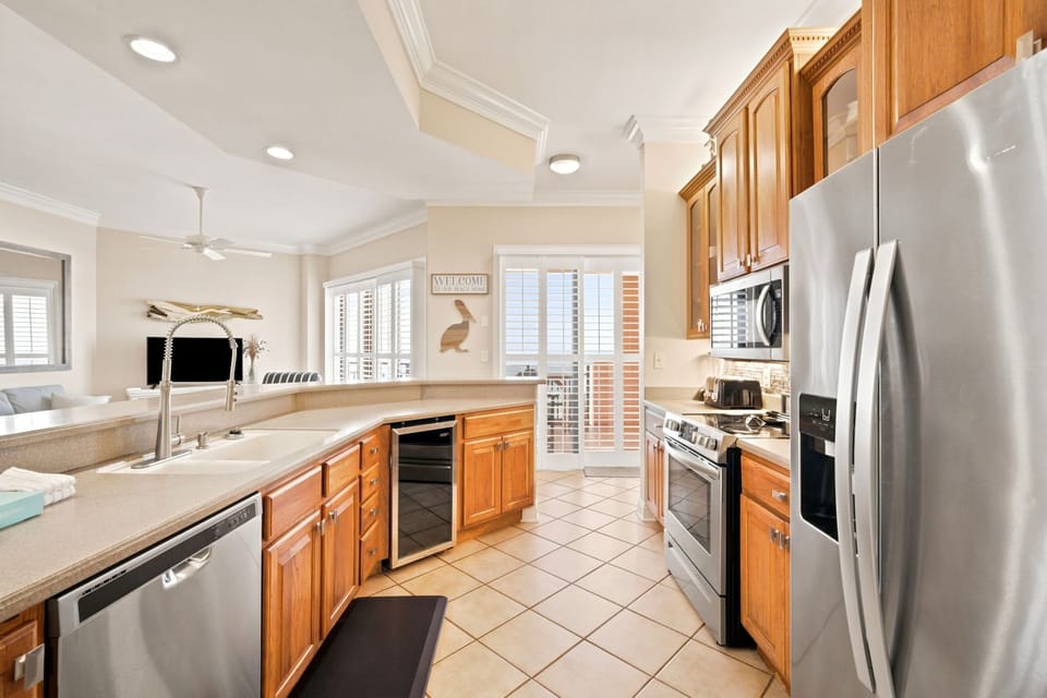 SeaChase 1104C- Your fully equipped kitchen features warm wood cabinets, stainless steel appliances, and plenty of counter space for preparing memorable vacation meals together.