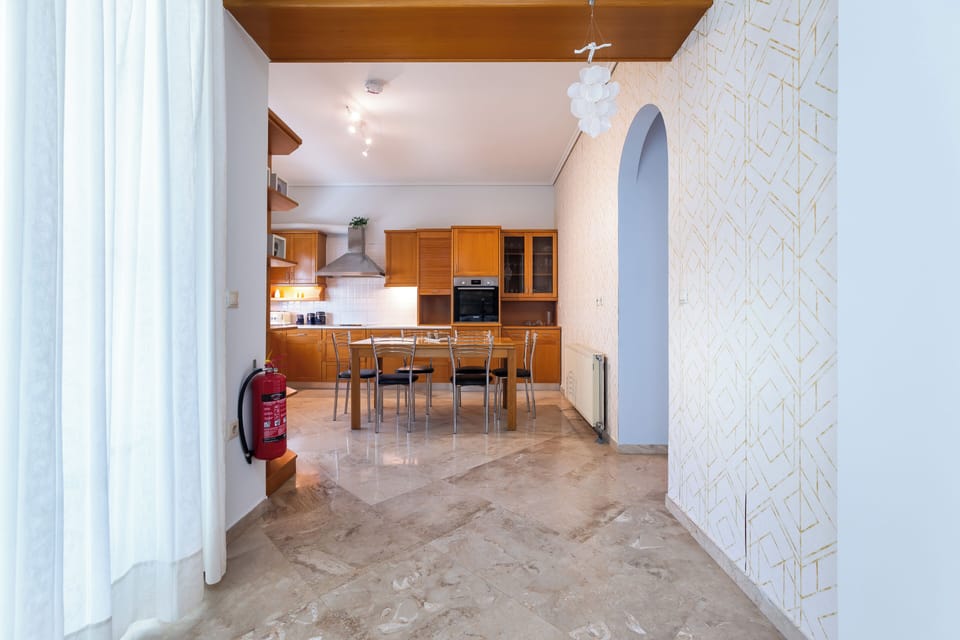 Spacious open-plan kitchen with natural light and modern wooden cabinets. 