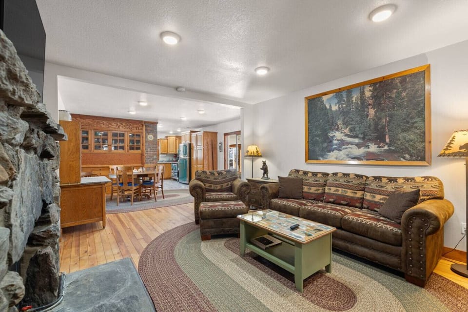 Admire rustic elegance in the living room, accented with a striking painting and rich, warm wood tones.