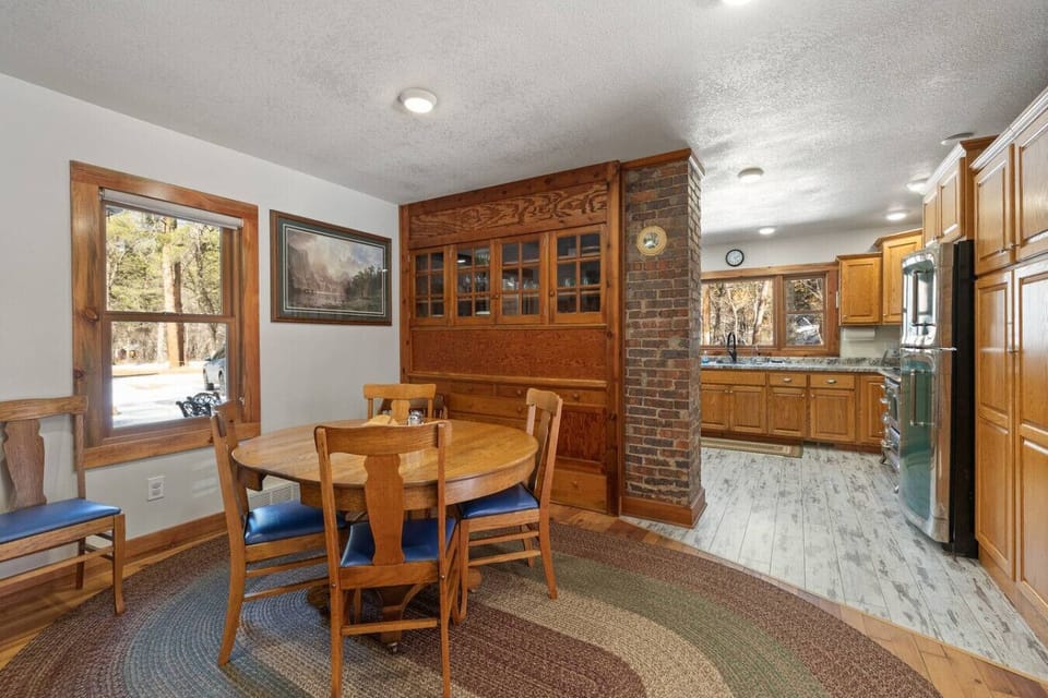 Enjoy meals together at the dining area, centered around a timeless wooden table and matching chairs