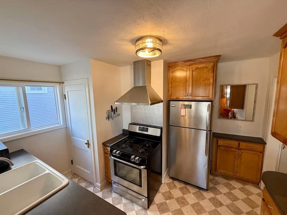 Gas stove, stainless vent hood, and full-size refrigerator for your home cooking