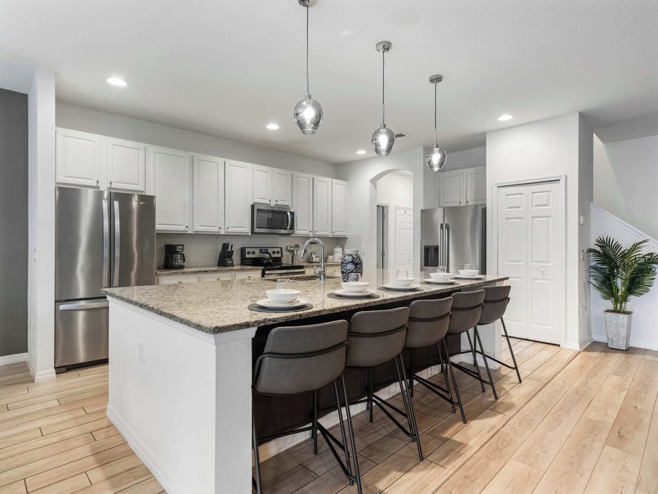 Bright modern kitchen w/ large island seating & sleek stainless appliances