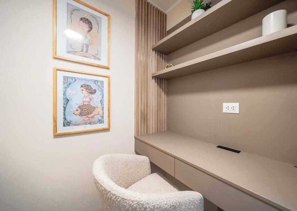 Oficina privada dentro de la recámara, con escritorio integrado, repisas decorativas y una silla cómoda. Un espacio ideal para trabajar, estudiar o usar como estación personal durante la estadía.