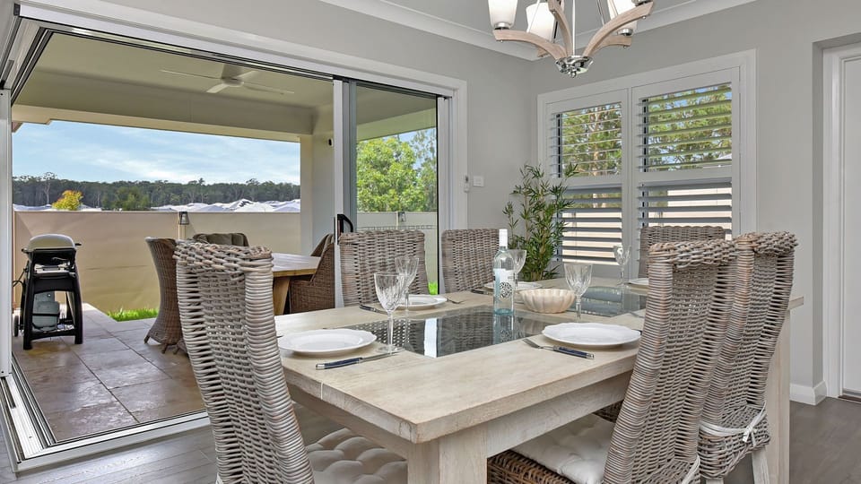 Elegant dining for six with beautiful indoor views through glass doors.