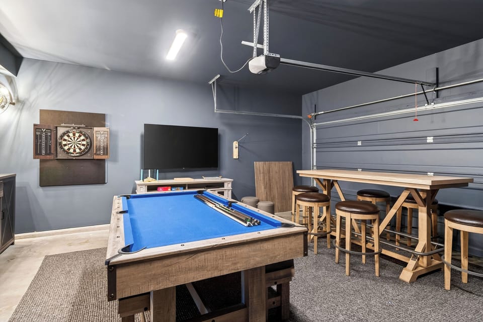 The game room is designed for all-ages fun with a pool table, arcade game, and bar area for laid-back nights in.