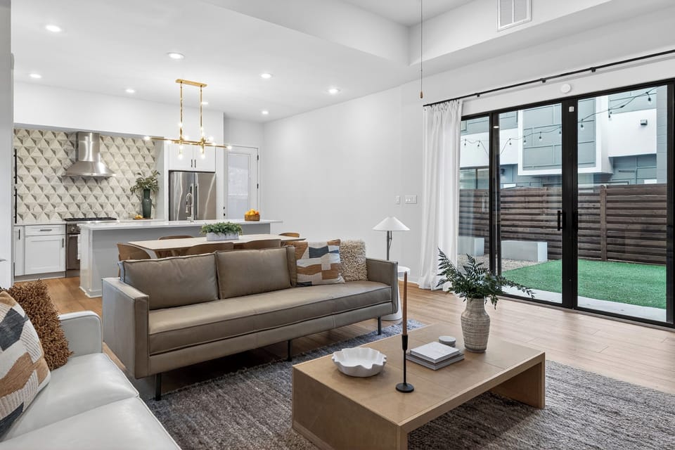 Airy, modern living room with a huge TV, cozy seating, and sliding doors to your private outdoor space.