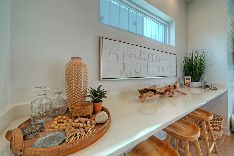 Stylish breakfast bar with coastal décor, natural textures, and seating for casual meals or morning coffee. (Dune & Done)