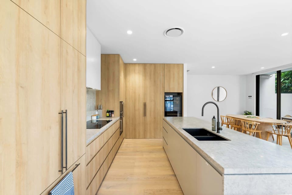 Designer kitchen with stone island bench, Gaggenau appliances and built-in fridge.