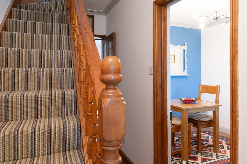 Ground floor: Stairs to the first floor, and view of table for two (or four) in the sitting room