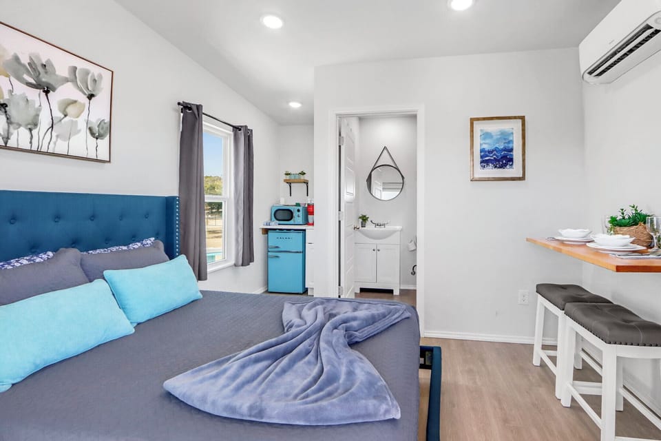 The stylish studio features a cozy bed, modern kitchenette, and thoughtful touches throughout