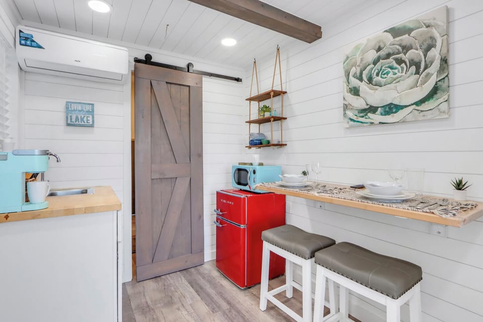 The kitchenette features rustic barn doors and overhead exposed beam