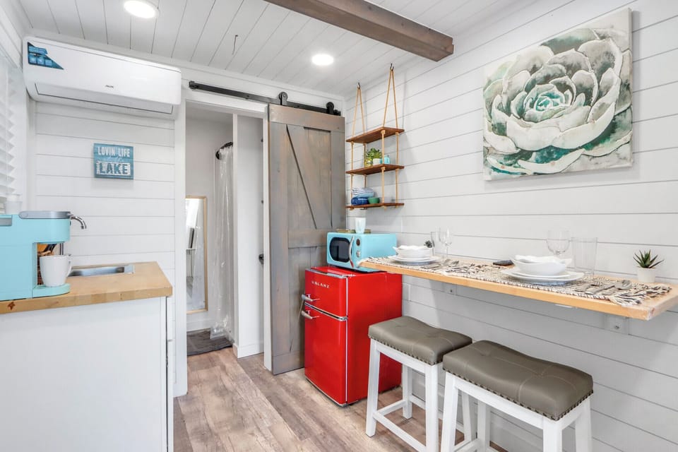 The kitchenette features rustic barn doors and overhead exposed beam
