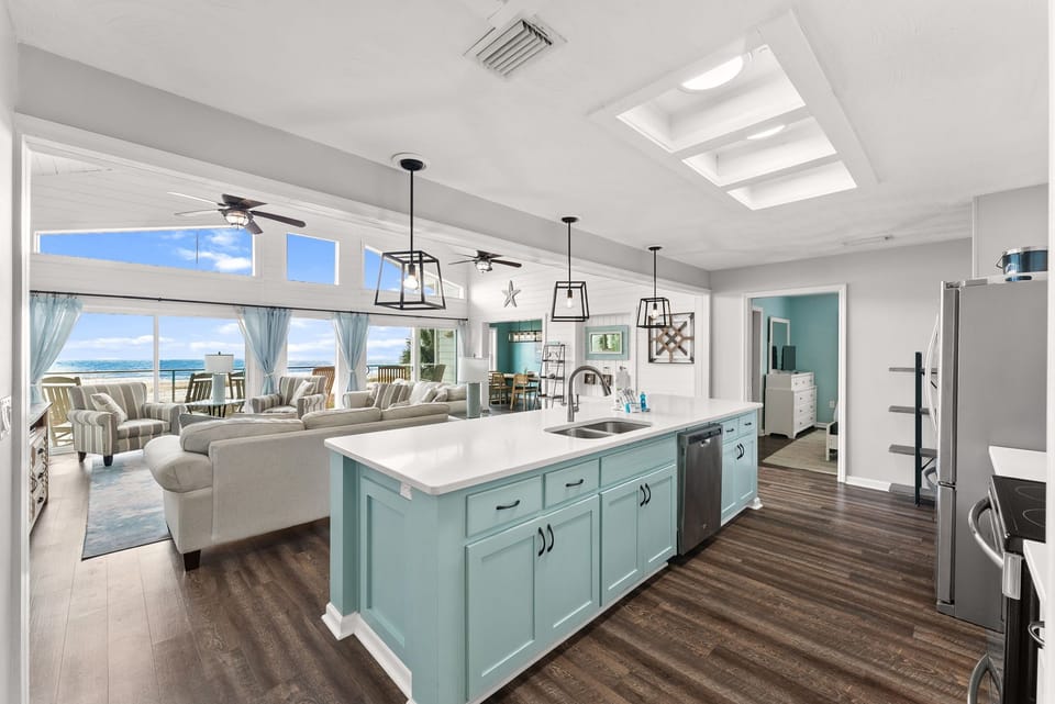 Your spacious kitchen island overlooks stunning ocean views, perfect for preparing meals while enjoying the coastal breeze through open windows.