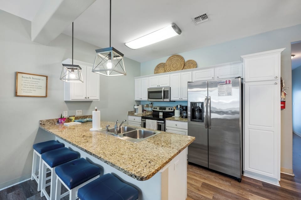 Your fully equipped kitchen awaits with granite counters, stainless appliances, and breakfast bar seating for casual meals and morning coffee.