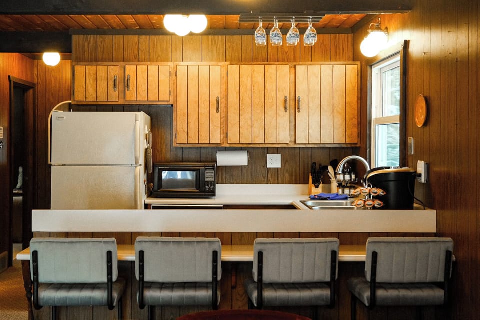 Cozy cabin-style kitchen with breakfast bar seating for four