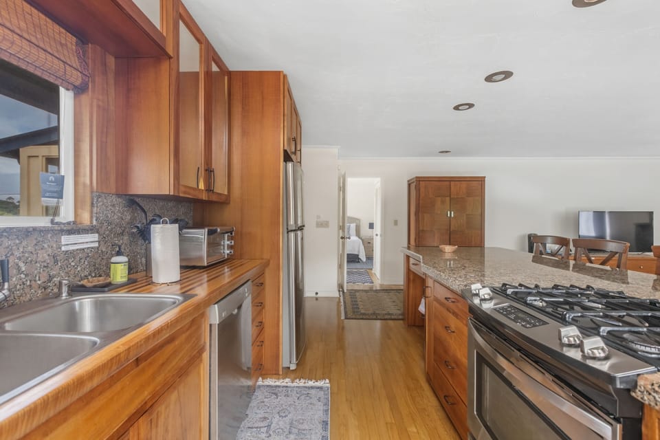 Upstairs / Kitchen: Main-level Kitchen with koa cabinets, pantry, granite island