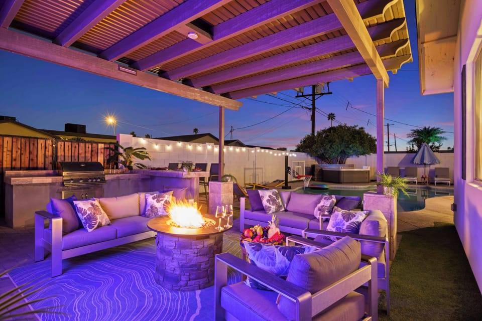 Stylish patio with fire pit, BBQ, and poolside lounge under sunset skies ✨
