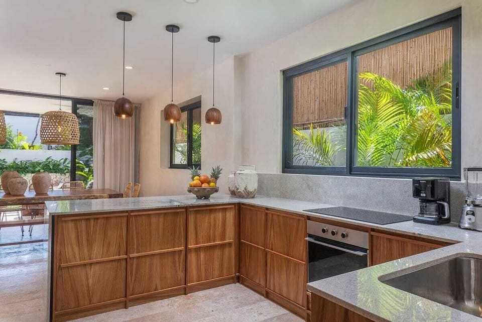 Delicate kitchen with wooden finishes. New appliances and a view of the garden.