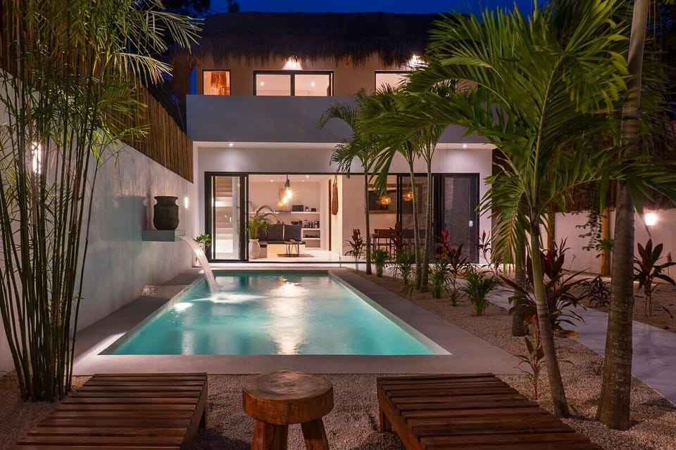 Pool with impressive lighting for nighttime enjoyment. Elegant loungers located on the side.
