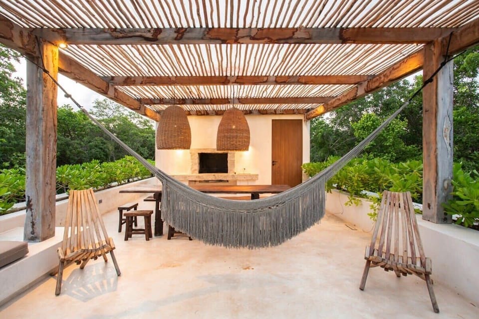 Terrace with a beautiful hanging hammock. It features an incredible covered outdoor dining area.