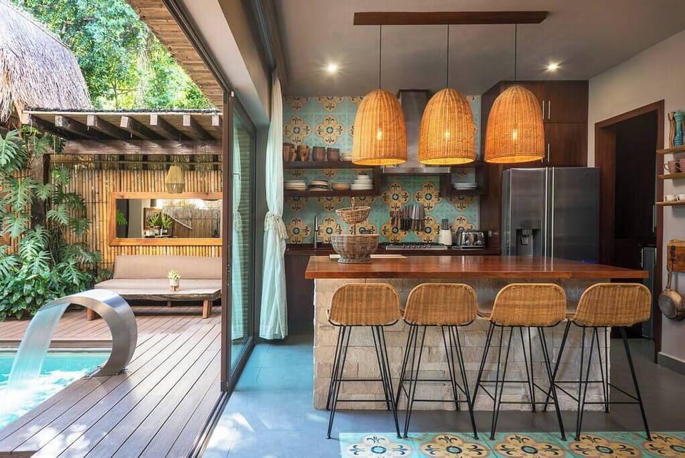 Modern and trendy kitchen with a spectacular island in the center. To the right, large windows connect to the patio and harmoniously blend the space