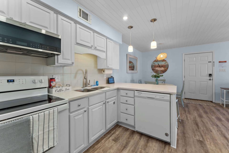 Another view of the kitchen highlights the clean finishes and full appliance setup.