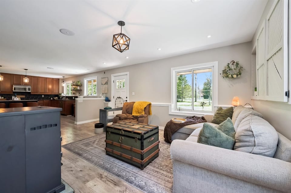 Relaxing seating area with large windows bringing in natural light and views of the surrounding countryside.